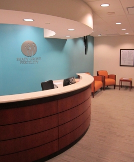 The curved receptionist desk at Shady Grove Fertility in front of a soft blue wall