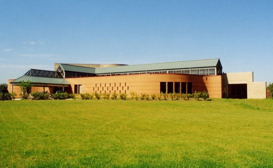 An exteriror photo Kettering Largo Lake Arbor Community Center showing a wide view of brick walls and green metal roofing material