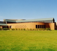 An exteriror photo Kettering Largo Lake Arbor Community Center showing a wide view of brick walls and green metal roofing material